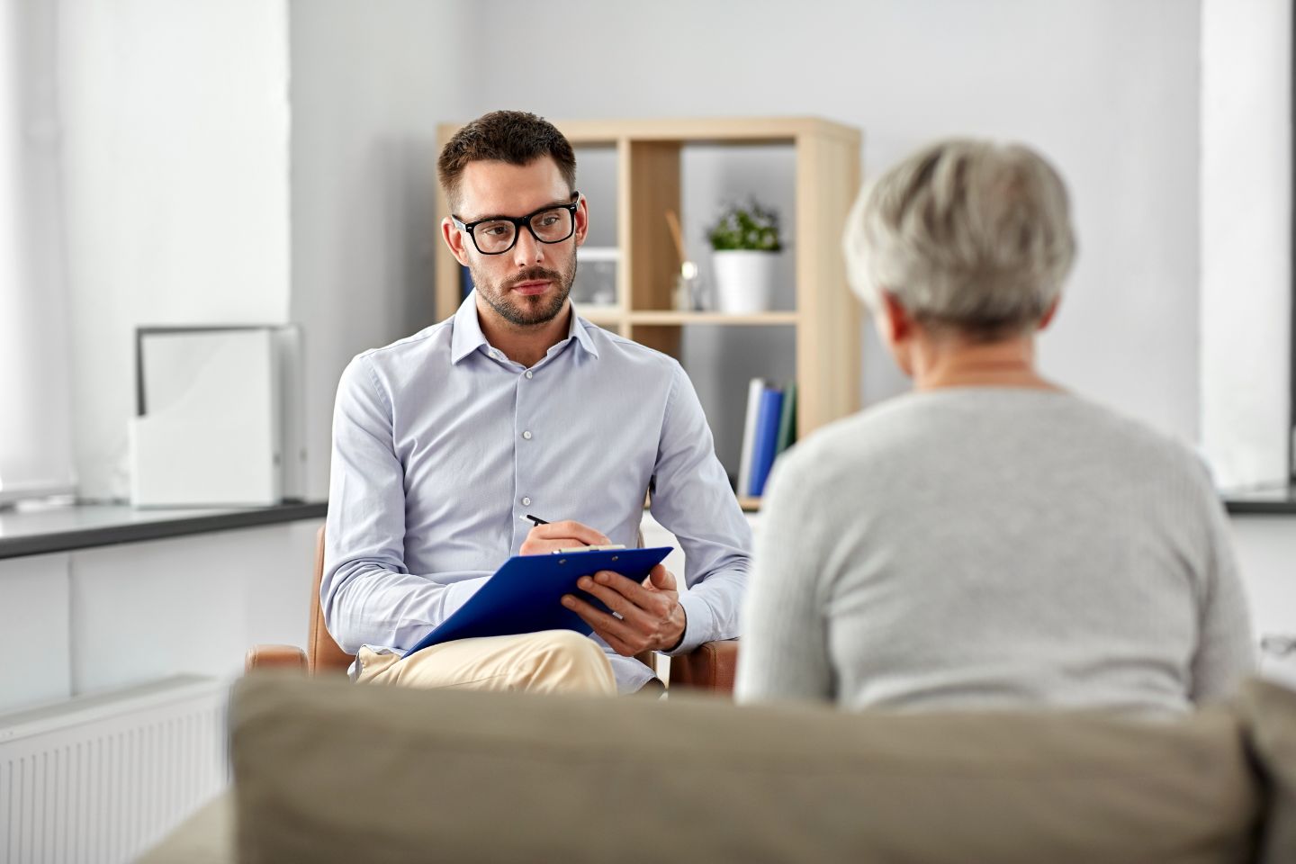 Psicólogo conversando sobre saúde mental com paciente em consultório de psicologia